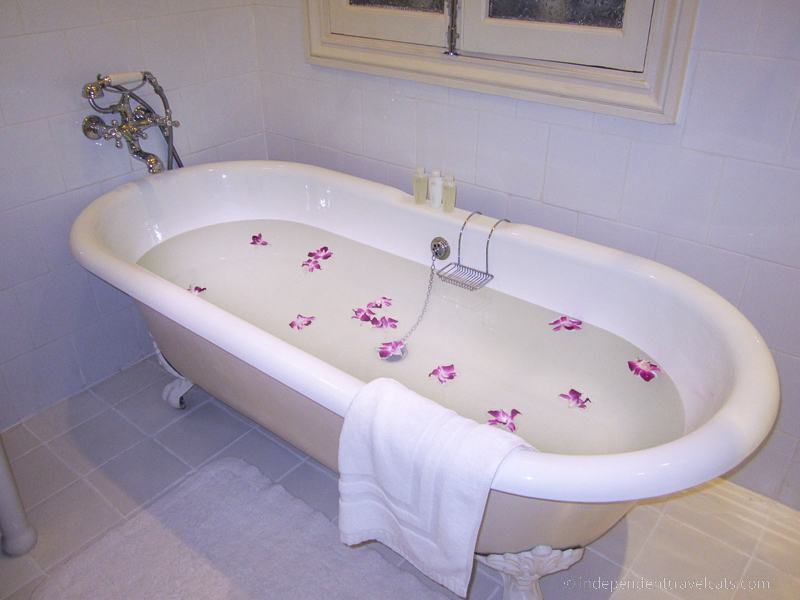 bathtub with flower petals taking a bath while traveling travel tips for bath lovers